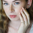 Close-up of a person wearing an aquamarine ring with diamond accents.