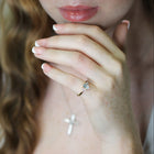 Close-up of a person wearing an aquamarine ring with diamond accents.