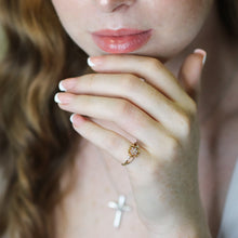 Close-up of a woman's hand with a ring  against a blurred background.