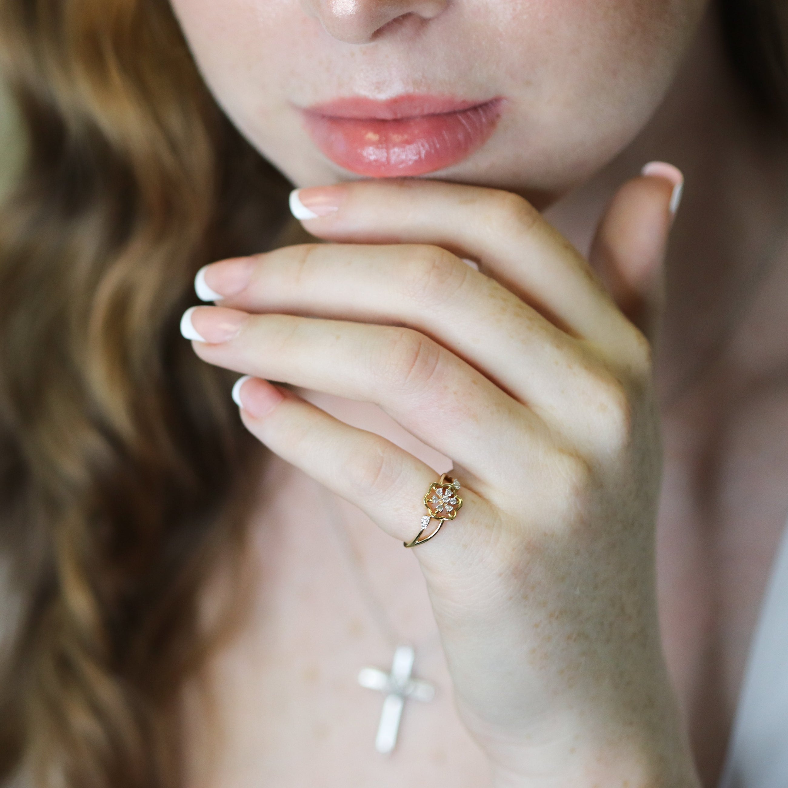 Close-up of a woman's hand with a ring  against a blurred background.