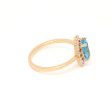 Gold ring with a blue gemstone on a white background