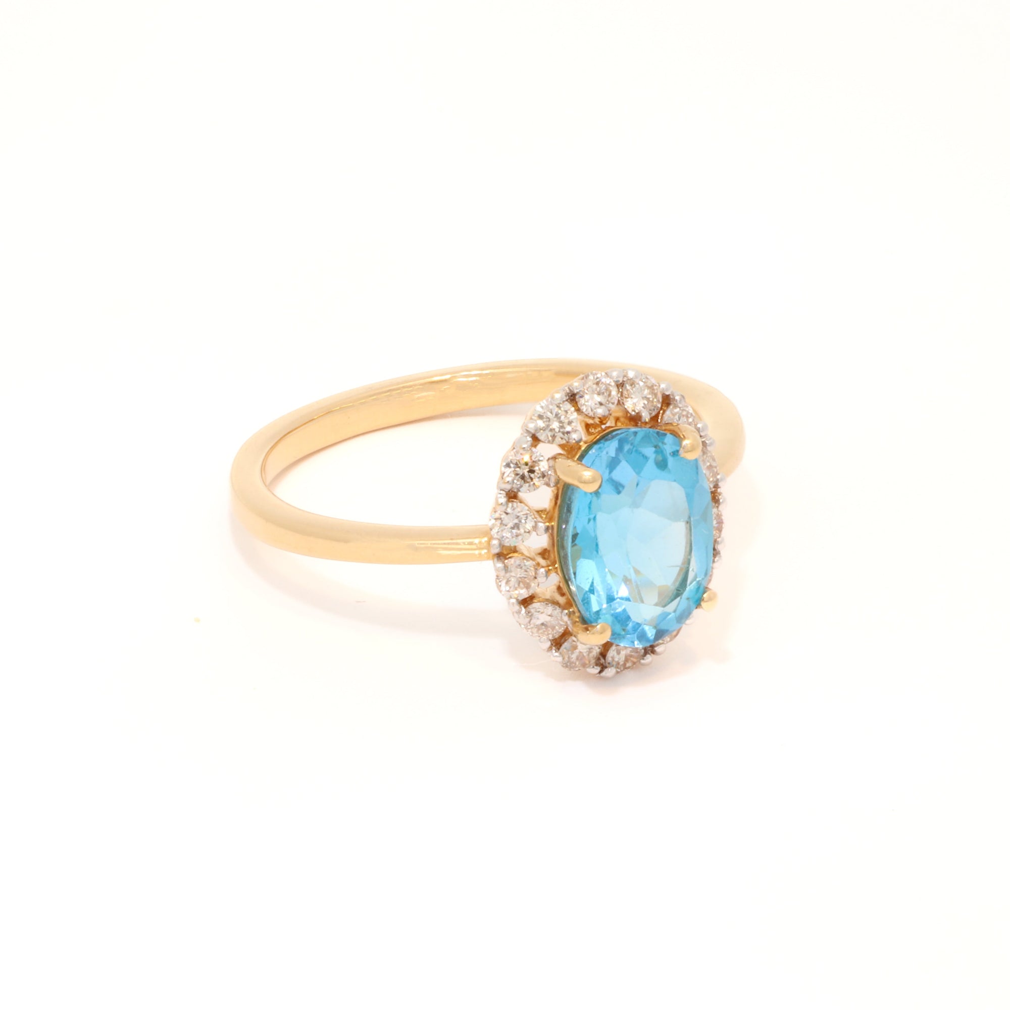 Gold ring with a blue gemstone and diamond accents on a white background