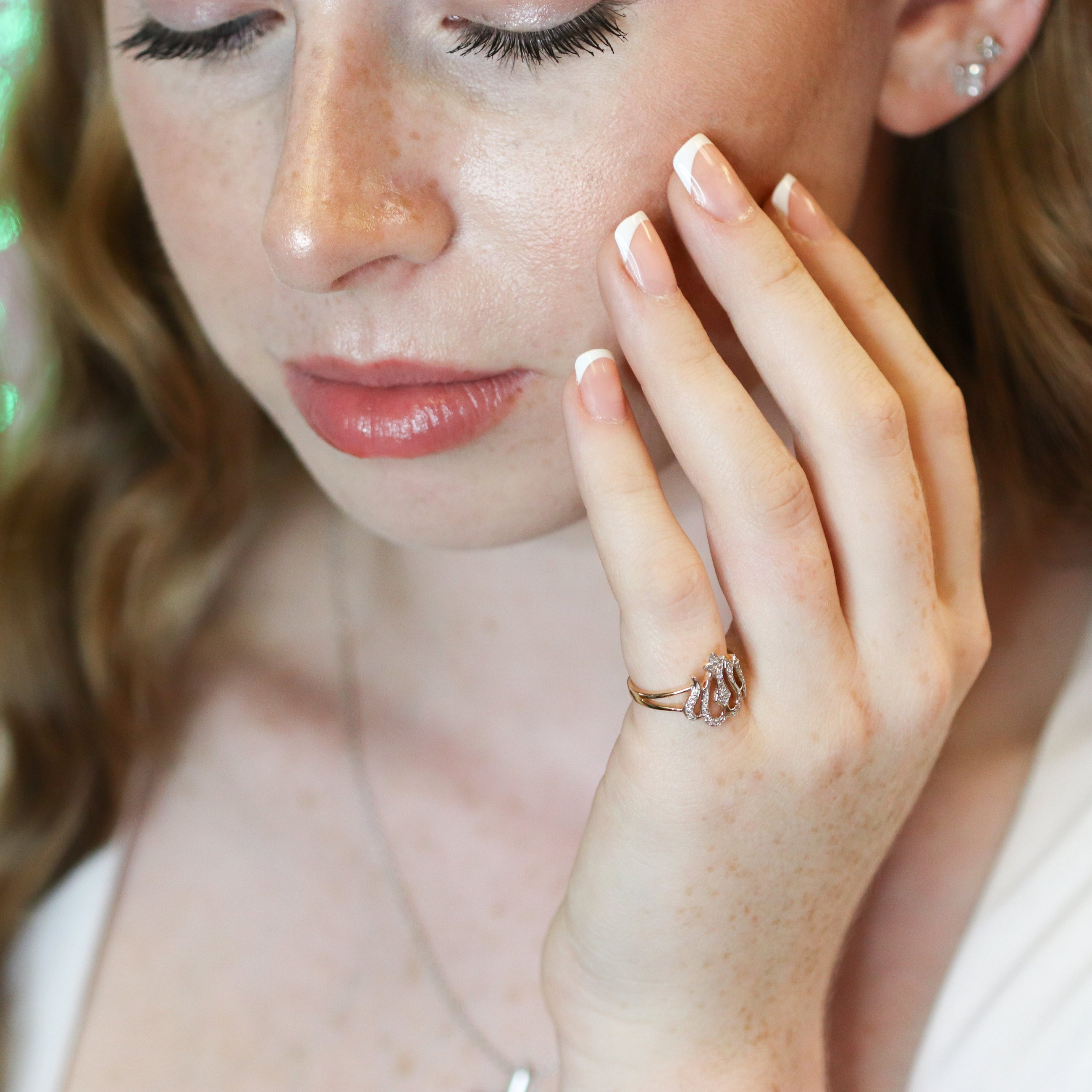 Woman wearing a ring with a green bokeh background
