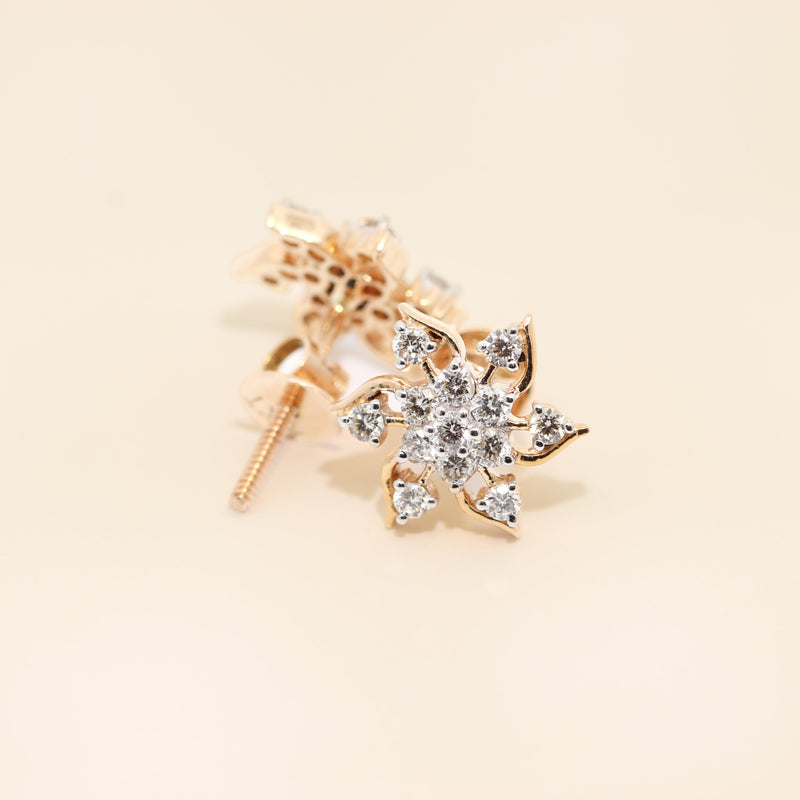 Gold star-shaped earring with clear gemstones on a beige background