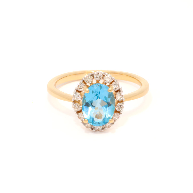 Gold ring with a blue-topaz and diamond accents on a white background.