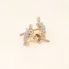 Gold and diamond earrings on a beige background