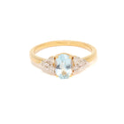 Gold ring with a aquamarine and diamond accents on a white background