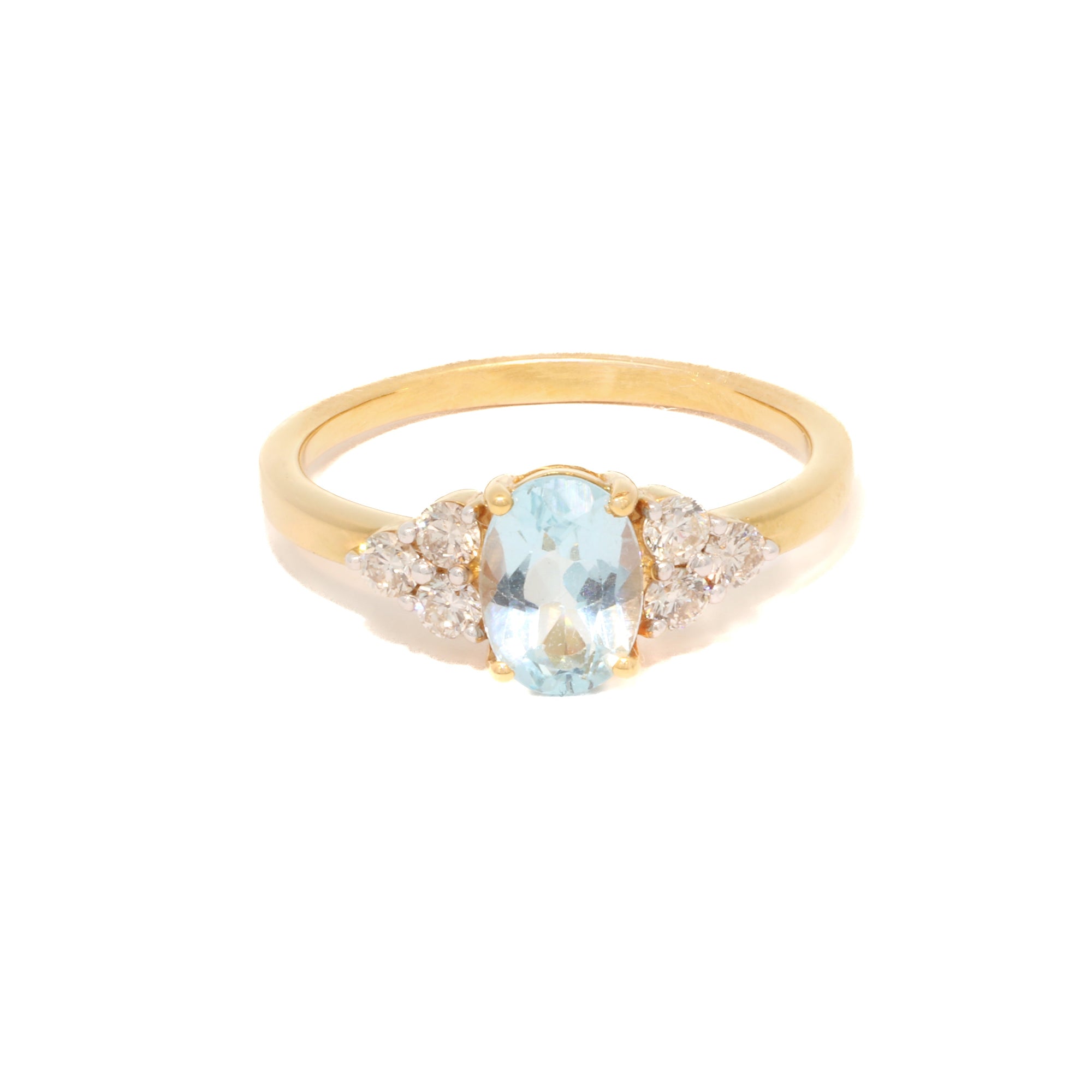 Gold ring with a aquamarine and diamond accents on a white background