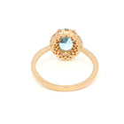 Gold ring with a blue gemstone on a white background