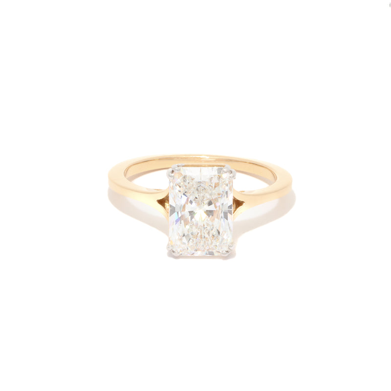 Gold ring with a radiant diamond on a white background