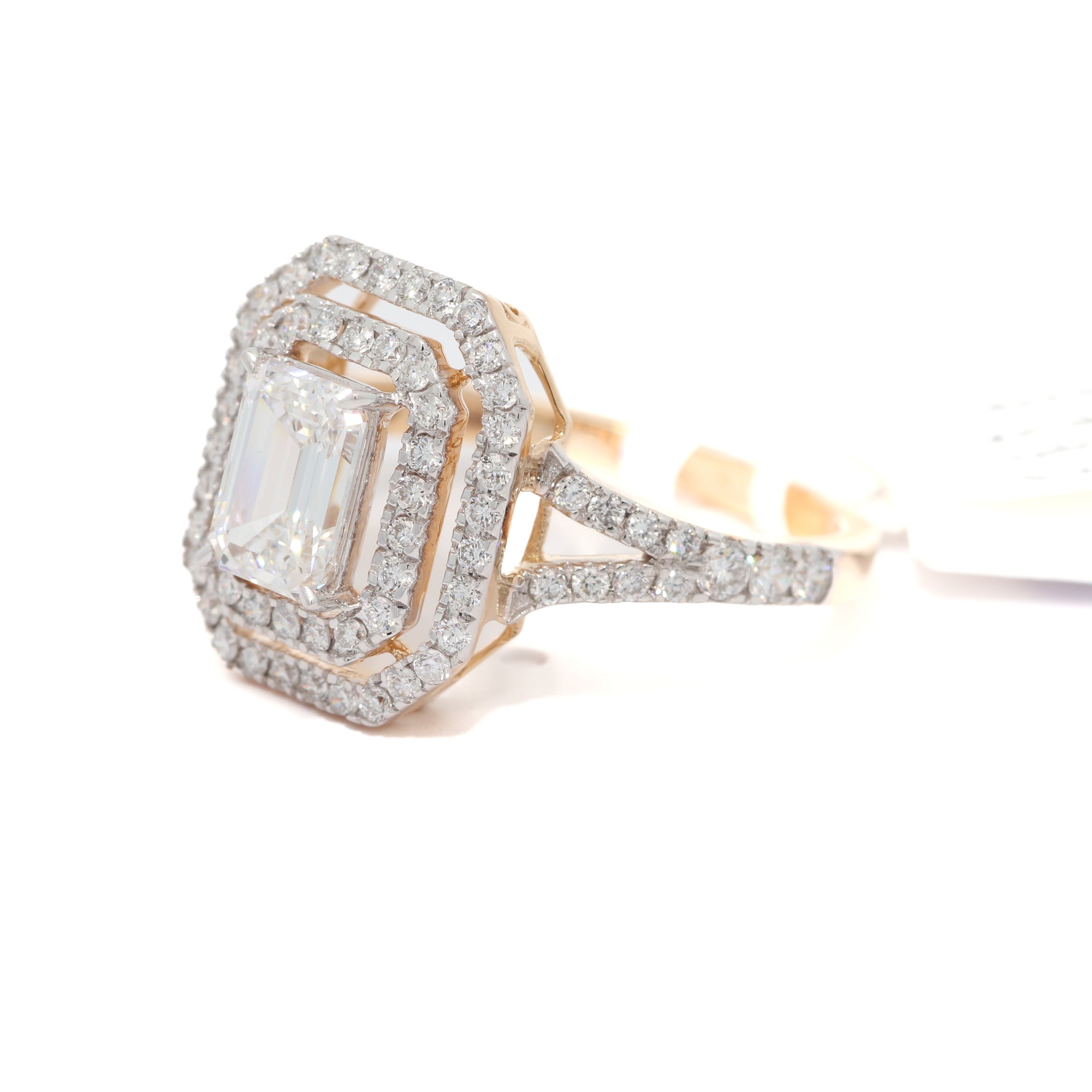 Yellow gold ring with a large diamond and smaller diamonds on the band against a white background