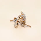 Gold earrings with diamond accents on a beige background