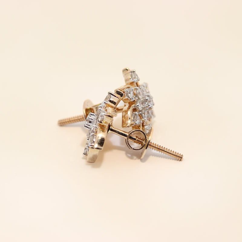 Gold earrings with diamond accents on a beige background