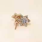 Gold earring with diamond stones on a beige background