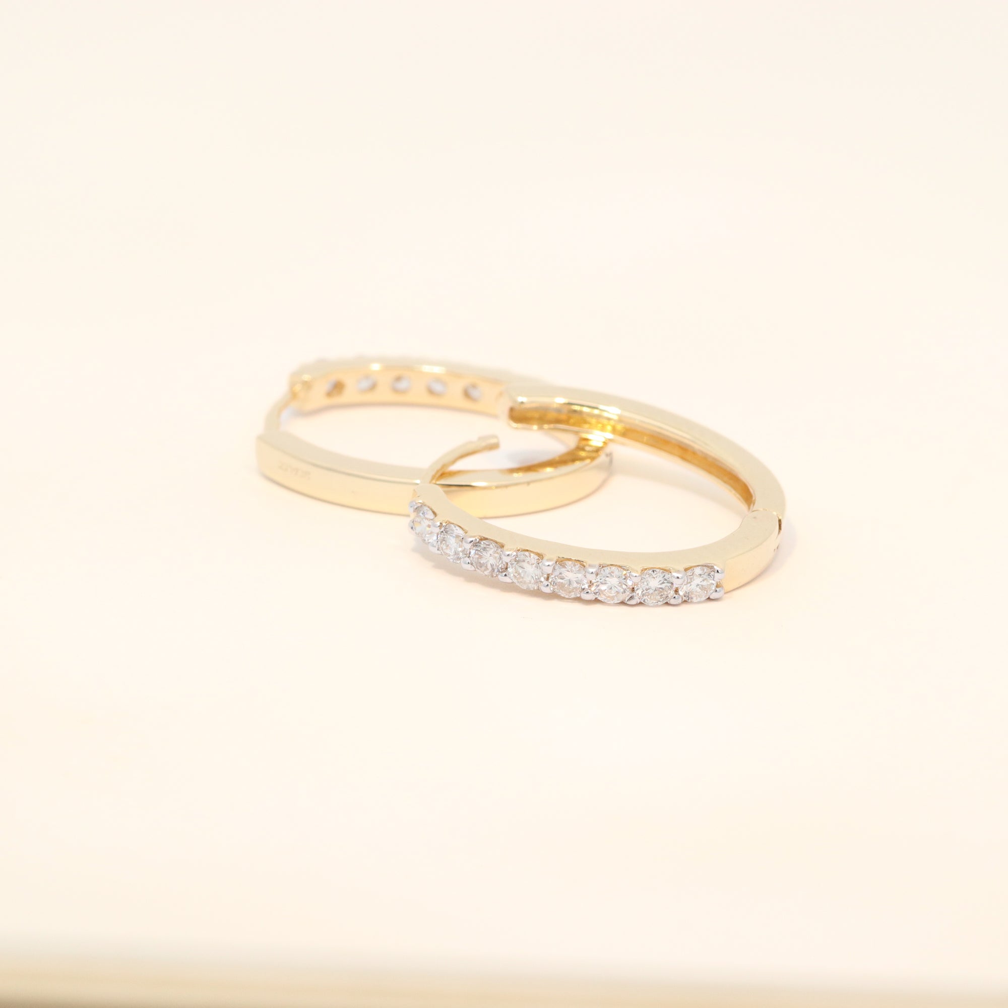 Two gold huggies with diamond accents.