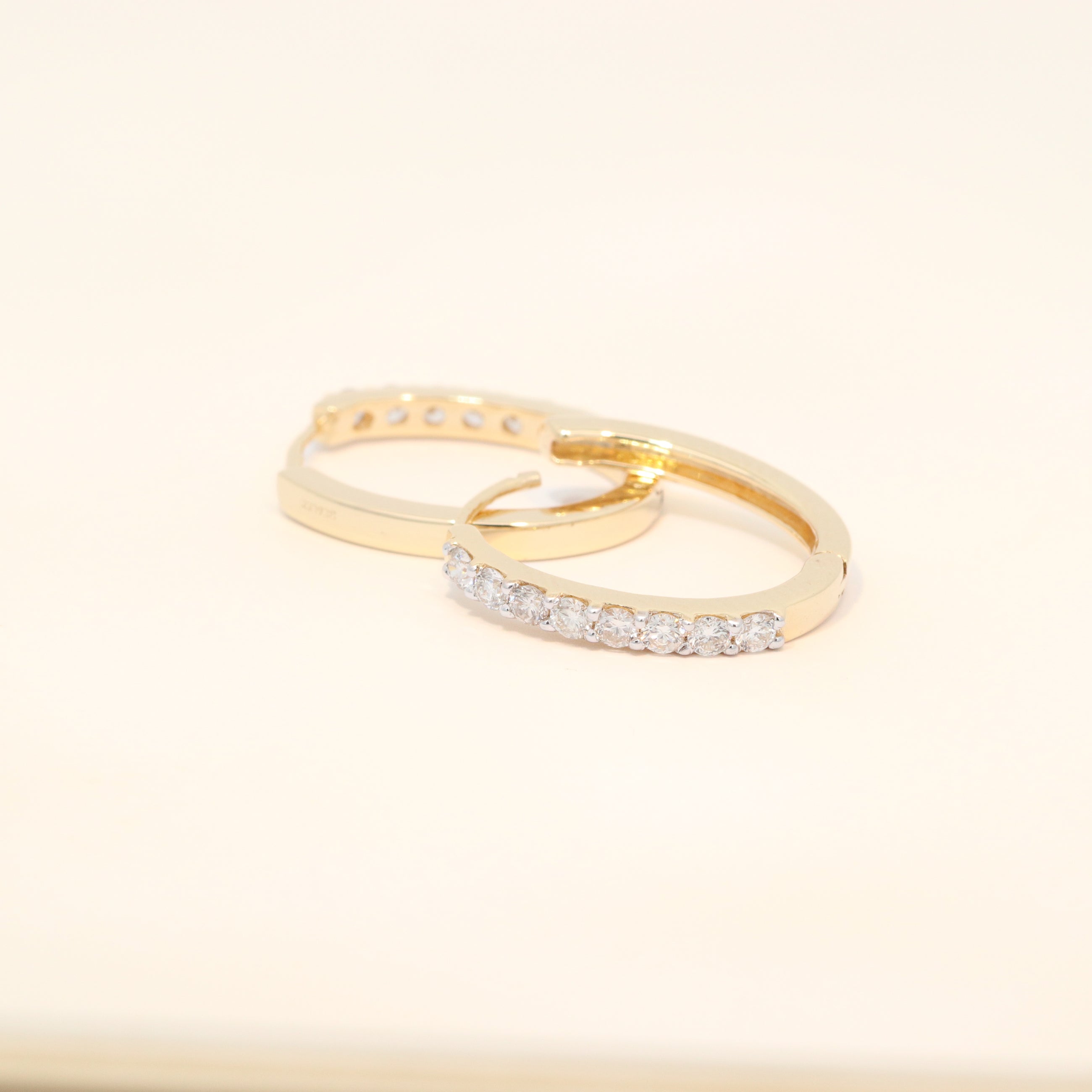 Two gold huggies with diamond accents.