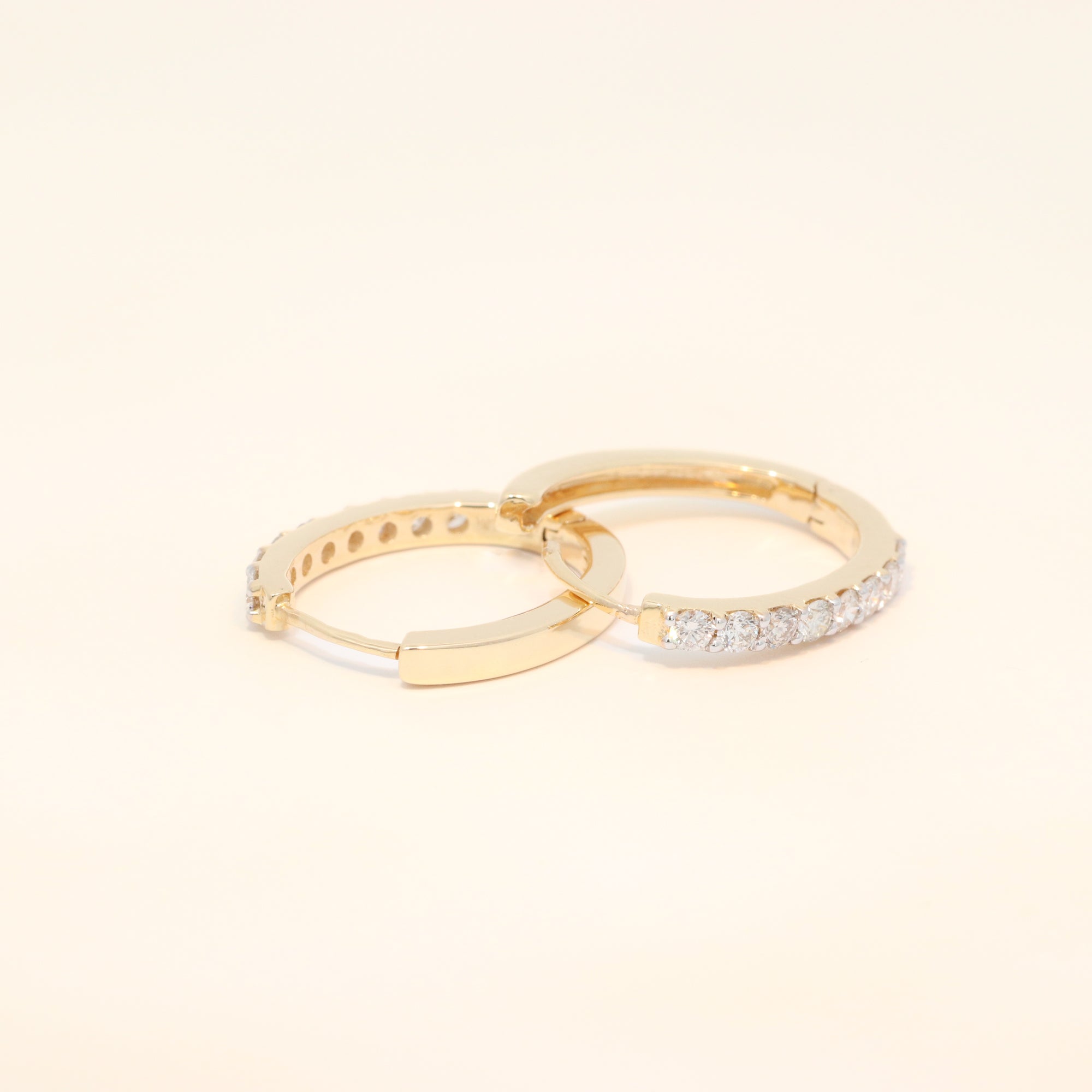 Two gold huggies with diamond accents.