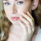 Woman wearing a diamond ring, with a soft focus background