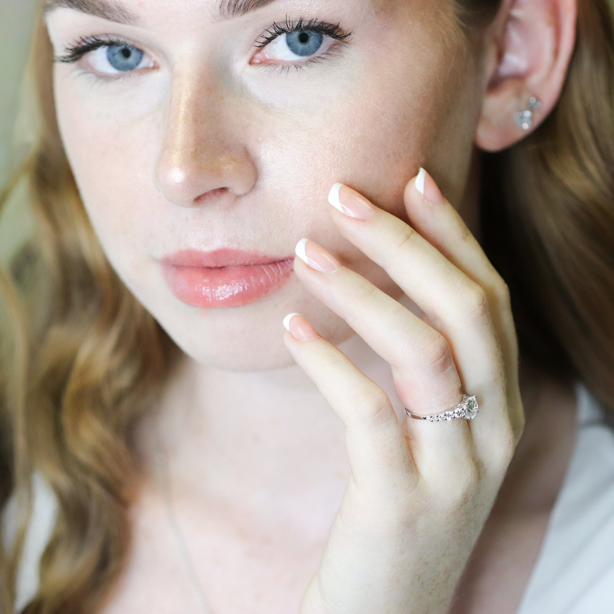 Woman wearing a diamond ring, with a soft focus background