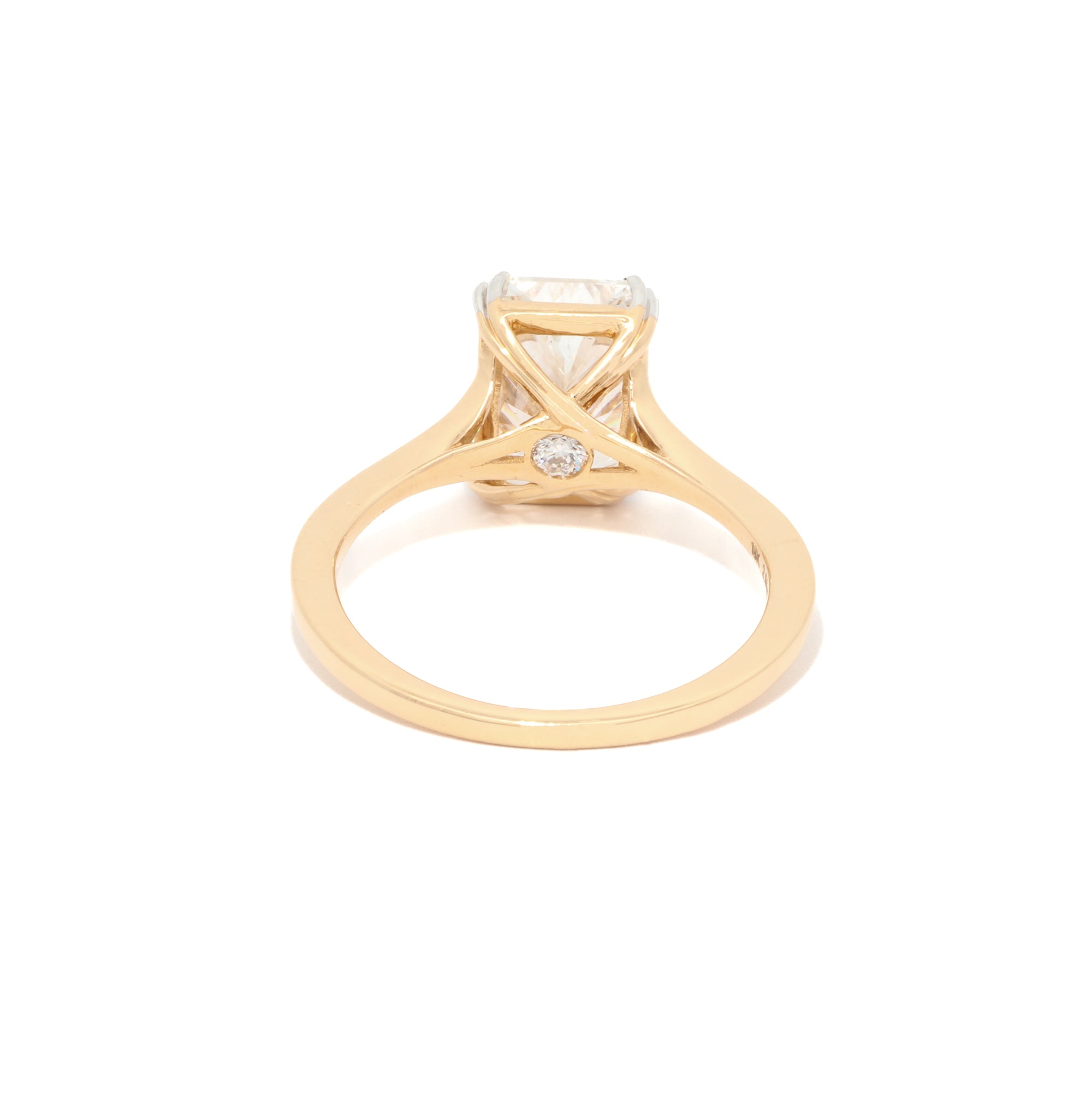 Yellow Gold ring with a radiant diamond on a white background