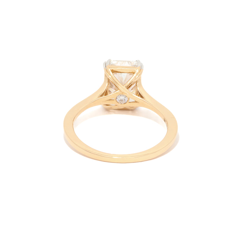 Yellow Gold ring with a radiant diamond on a white background